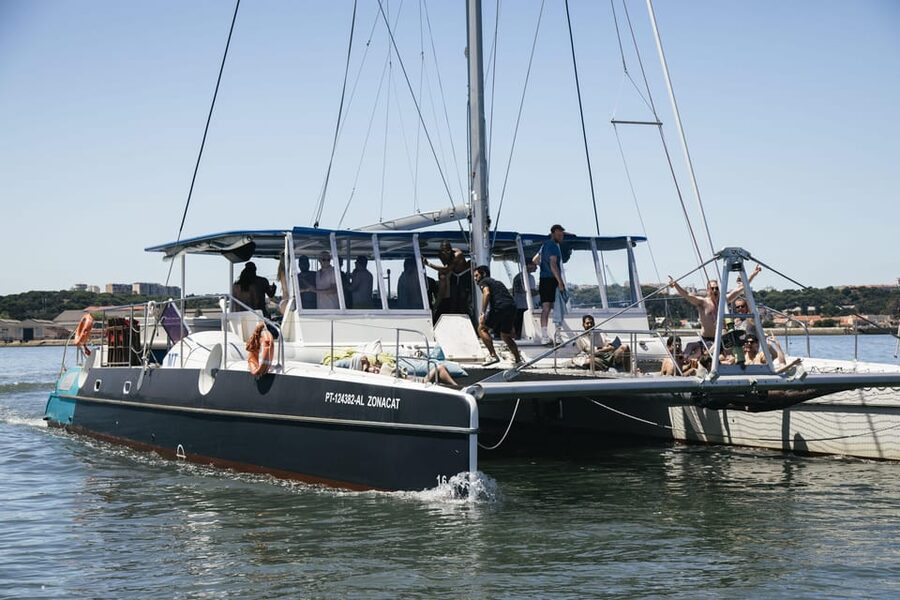 Lisbon: Catamaran Boat Party with Music, Open Bar & Dives - Cruising from Alcântara toward the waterfront sights