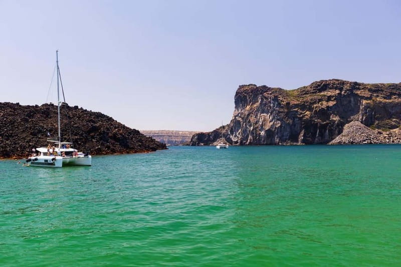 Santorini: Catamaran Cruise with Fresh Meal & Open Bar - Akrotiri Lighthouse and the caldera cliffs