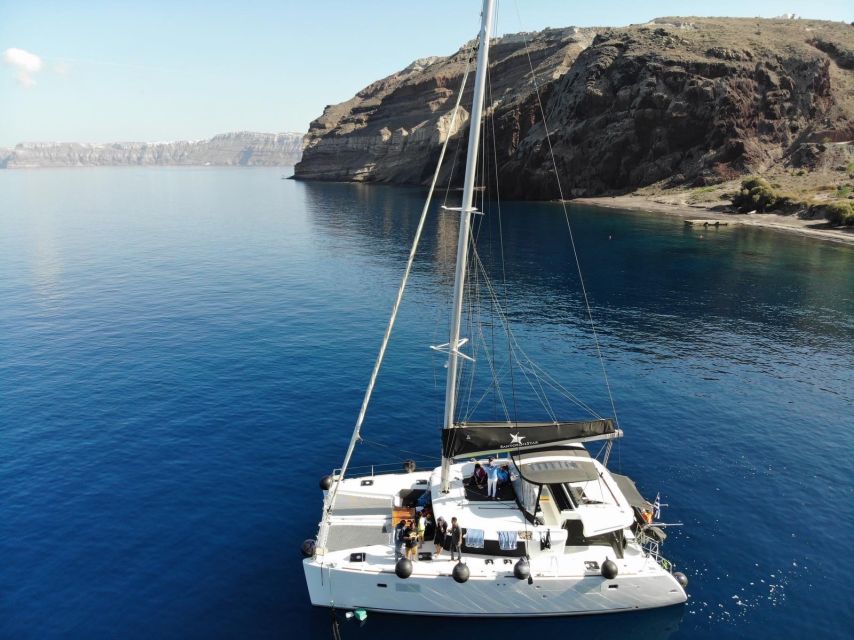 Santorini: Catamaran Cruise with Meal & Open Bar - The lighthouse, Indian Rock, and the volcanic coast